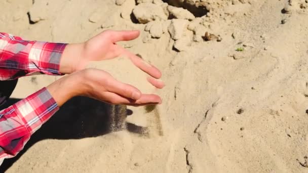 Een man houdt een zandverkoop in zijn handen. Selectieve focus. — Stockvideo