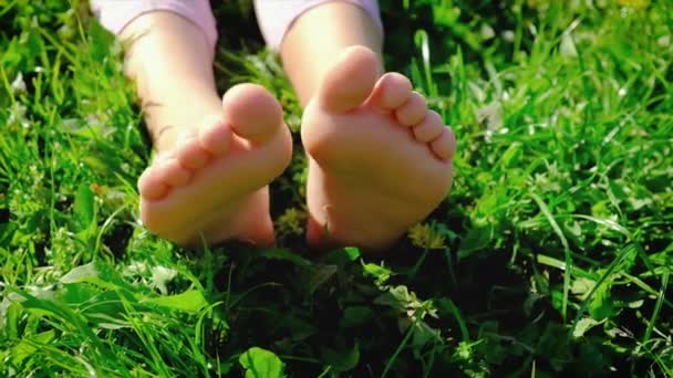 Dětské nohy na trávě v létě. Selektivní zaměření. — Stock video