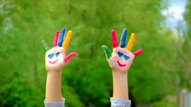 Çocuk boyalı bir gülümseme tutuyor. Seçici odak.