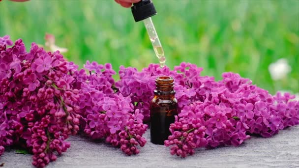 Óleo essencial de lilás e extrato em uma pequena garrafa. Foco seletivo. — Vídeo de Stock