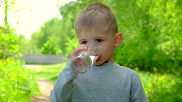 Barnet dricker vatten ur ett glas. Selektiv inriktning. — Stockvideo