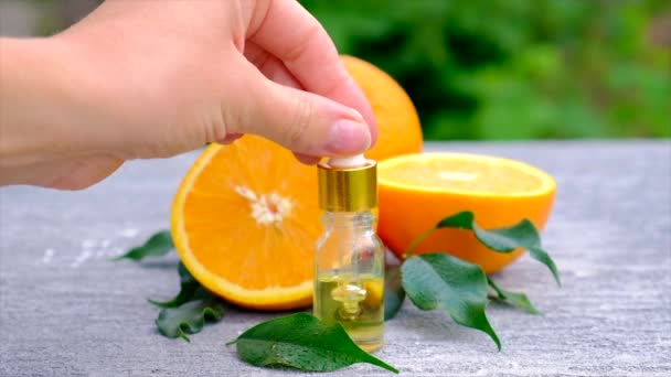 Ätherisches Orangenöl in einer kleinen Flasche. Selektiver Fokus. — Stockvideo