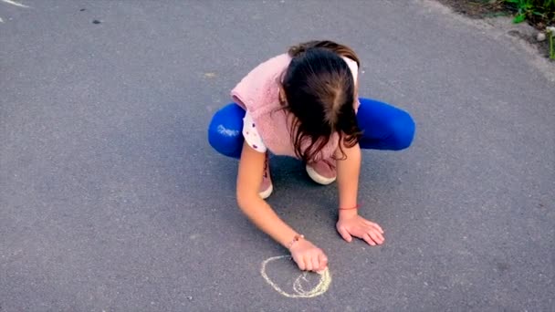 A criança desenha o sol no pavimento. Foco seletivo. — Vídeo de Stock