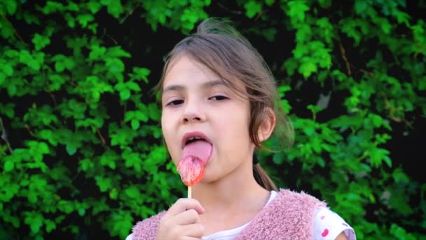 The child is eating a lollipop. Selective focus. — Stock Video