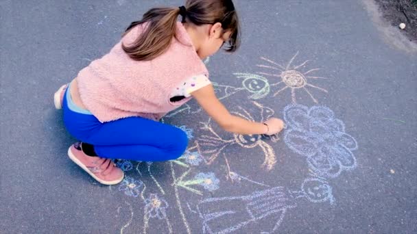 Das Kind zeichnet eine Familie auf den Asphalt. Selektiver Fokus. — Stockvideo