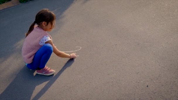 Barnet skriver matte på trottoaren. Selektiv inriktning. — Stockvideo