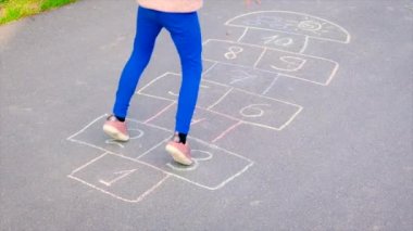 Çocuklar asfaltta zıplayan klasikleri oynarlar. Seçici odak.