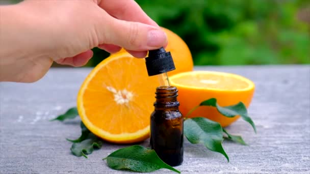Ätherisches Orangenöl in einer kleinen Flasche. Selektiver Fokus. — Stockvideo