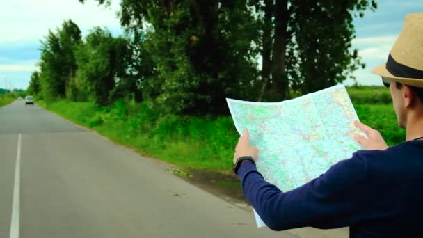 Ένας άντρας κοιτάζει ένα χάρτη στο δρόμο. Επιλεκτική εστίαση. — Αρχείο Βίντεο