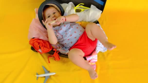 Bébé dans une valise pour se préparer pour un voyage. Concentration sélective. — Video