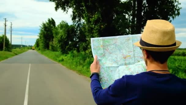 Een man kijkt naar een kaart op de weg. Selectieve focus. — Stockvideo