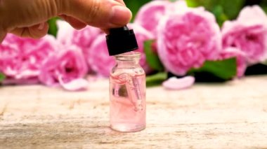 Çay gülü yağı küçük bir şişede. Seçici odak.