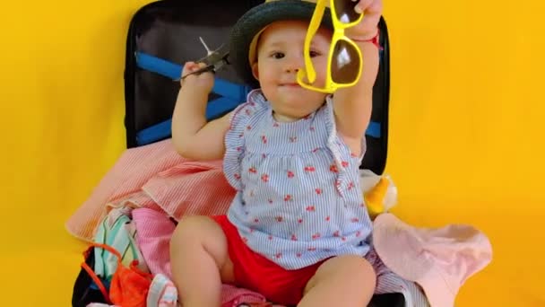 여행 준비하려고 여행 가방 안에 있는 아기. 선택적 초점. — 비디오