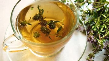 Şeffaf bir fincanda kekik ile çay. Seçici odak.