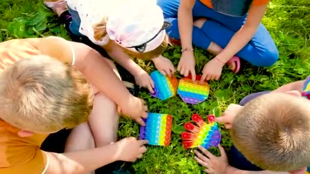 Les enfants jouent ensemble sur pop it. Concentration sélective. — Video