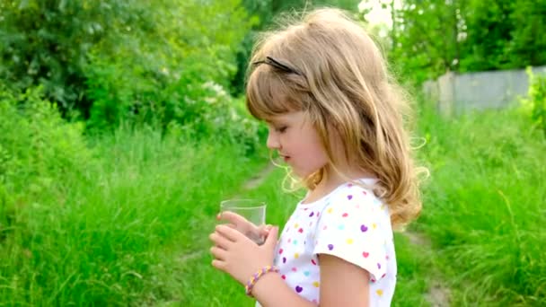 Ребёнок пьёт воду из стакана. Селективный фокус. — стоковое видео