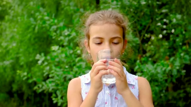 Menina bebe água de um copo. Foco seletivo. — Vídeo de Stock