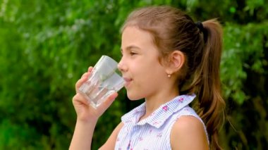 Çocuk kız bardaktan su içer. Seçici odak.