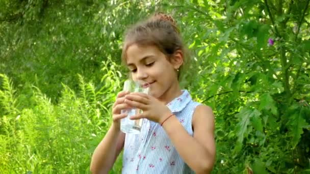 Девочка пьет воду из стакана. Селективный фокус. — стоковое видео