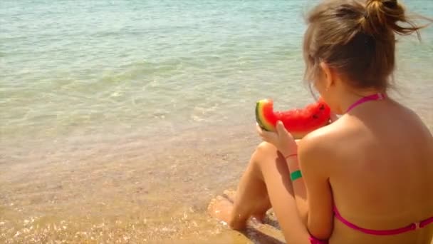 Dziecko jedzące arbuza w pobliżu morza. ukierunkowanie selektywne. — Wideo stockowe