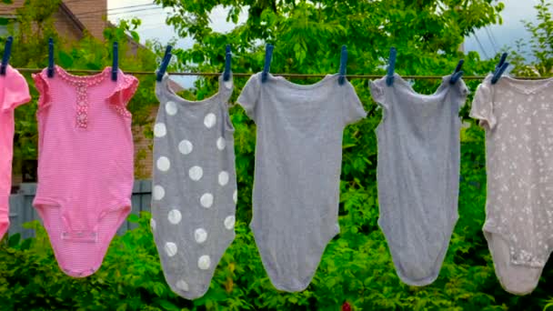 Babykleidung wird draußen getrocknet. Selektiver Fokus. — Stockvideo