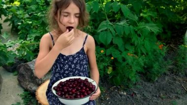Çocuk bahçede kiraz yiyor. Seçici odak.