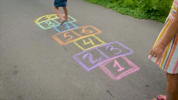 Kinder spielen Klassiker auf dem Asphalt. Selektiver Fokus. — Stockvideo