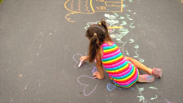 Il bambino disegna con il gesso sull'asfalto. Focus selettivo. — Video Stock