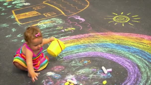 Das Kind zeichnet mit Kreide einen Regenbogen. Selektiver Fokus.