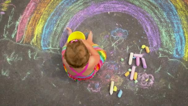 L'enfant dessine un arc-en-ciel à la craie. Concentration sélective. — Video