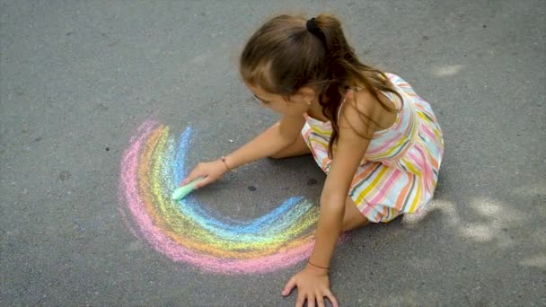 L'enfant dessine un arc-en-ciel à la craie. Concentration sélective. — Video