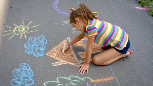 Il bambino disegna con il gesso sull'asfalto. Focus selettivo. — Video Stock