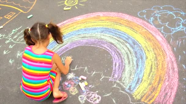 Het kind tekent een regenboog met krijt. Selectieve focus. — Stockvideo