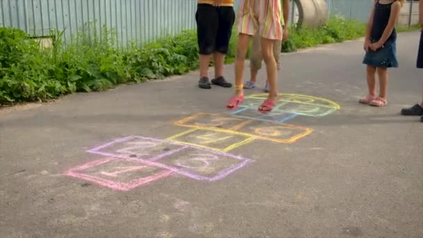 Kinder spielen Klassiker auf dem Asphalt. Selektiver Fokus. — Stockvideo