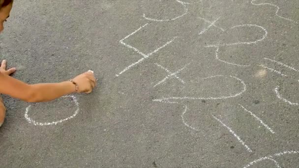 Dítě píše rovnice na asfalt. Selektivní zaměření. — Stock video