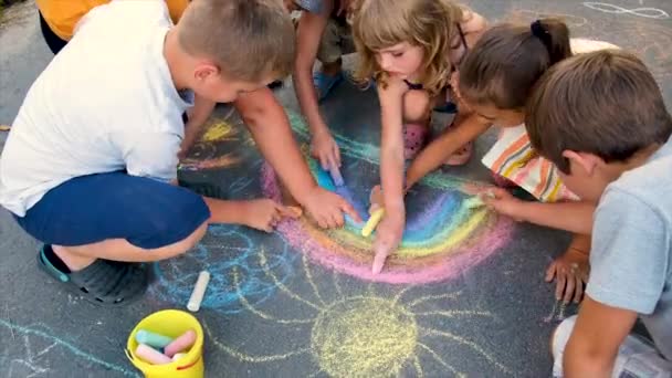 El niño dibuja un arco iris con tiza. Enfoque selectivo. — Vídeos de Stock