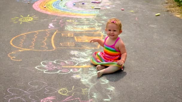 L'enfant dessine à la craie sur l'asphalte. Concentration sélective. — Video