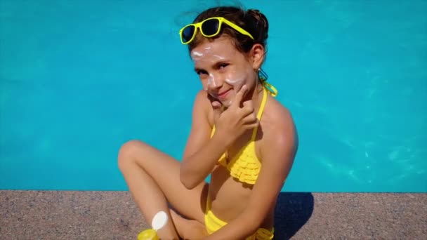 L'enfant lui colle de la crème solaire sur le visage. Concentration sélective. — Video