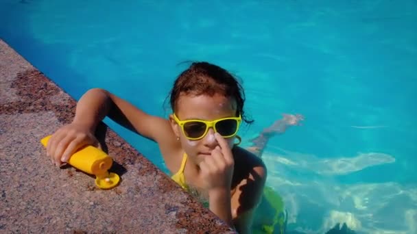 A criança mancha protetor solar em seu rosto. Foco seletivo. — Vídeo de Stock