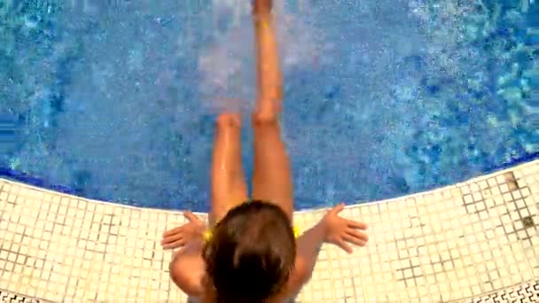 L'enfant joue au bord de la piscine. Concentration sélective. — Video