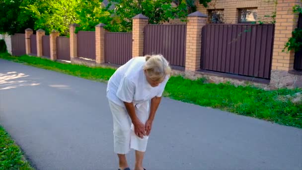 The old woman has a knee pain. Selective focus. — Stock Video