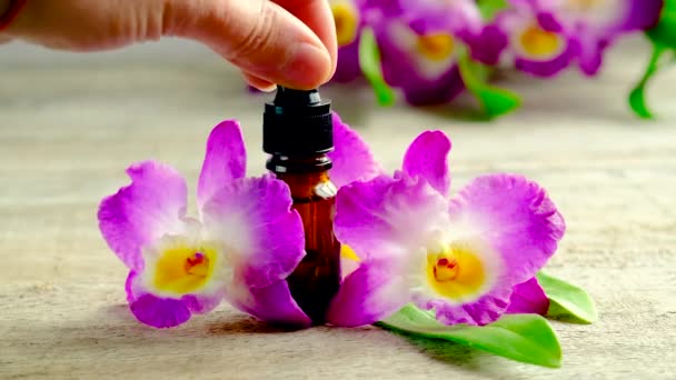 Orchidee etherische olie in een flesje. Selectieve focus. — Stockvideo