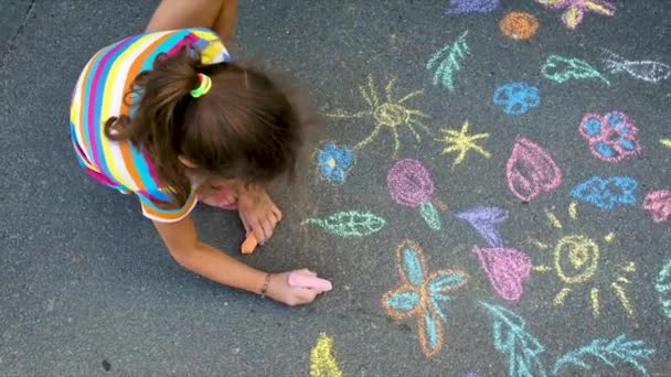 Il bambino disegna con il gesso sull'asfalto. Focus selettivo. — Video Stock