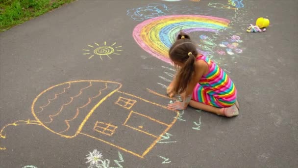 The child draws a rainbow with chalk. Selective focus. — Stock Video