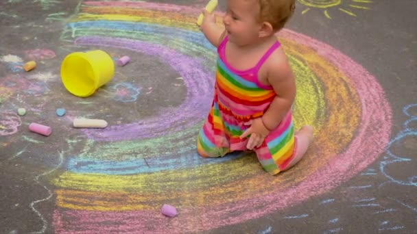 Дитина малює веселку з крейдою. Вибірковий фокус . — стокове відео