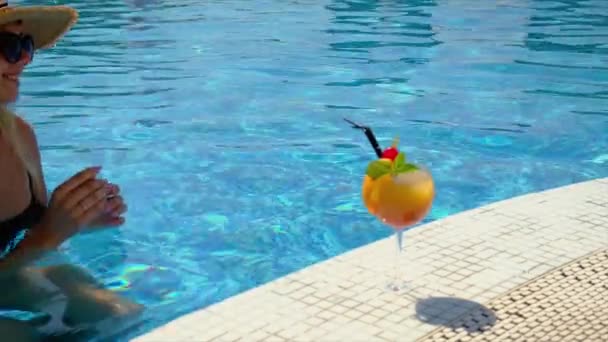 Mujer con cóctel cerca de la piscina. Enfoque selectivo. — Vídeo de stock