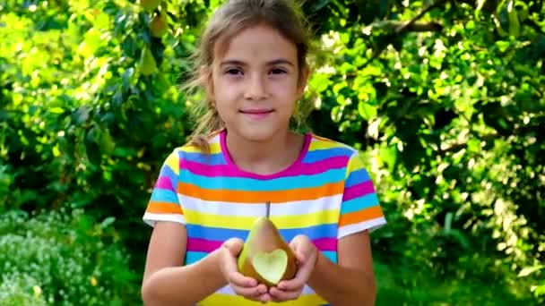 Il bambino mangia una pera in giardino. Focus selettivo. — Video Stock