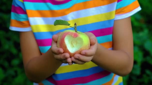El niño come una manzana en el jardín. Enfoque selectivo. — Vídeo de stock