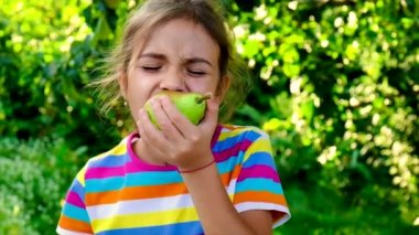 Çocuk bahçede bir armut yiyor. Seçici odak.