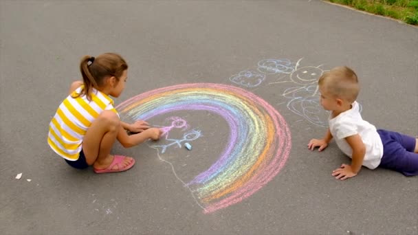 A gyerekek krétával rajzolnak az aszfalton. Szelektív fókusz. — Stock videók
